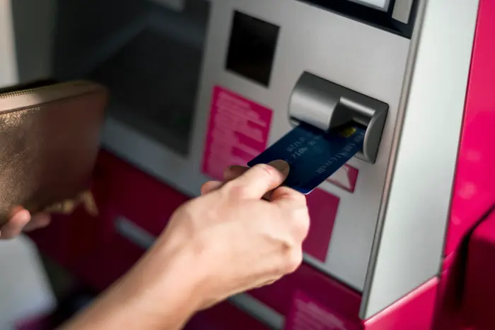 Person inserting card into ATM machine