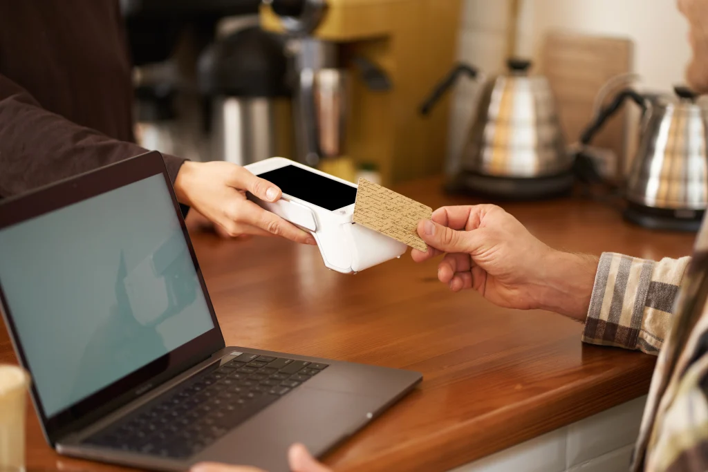 cropped-shot-male-hand-paying-contactless-his-order-coffee-shop-sitting-counter-with