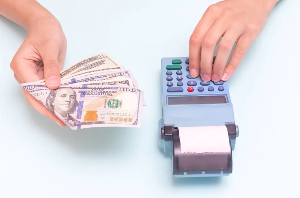 hands exchanging cash at payment terminal