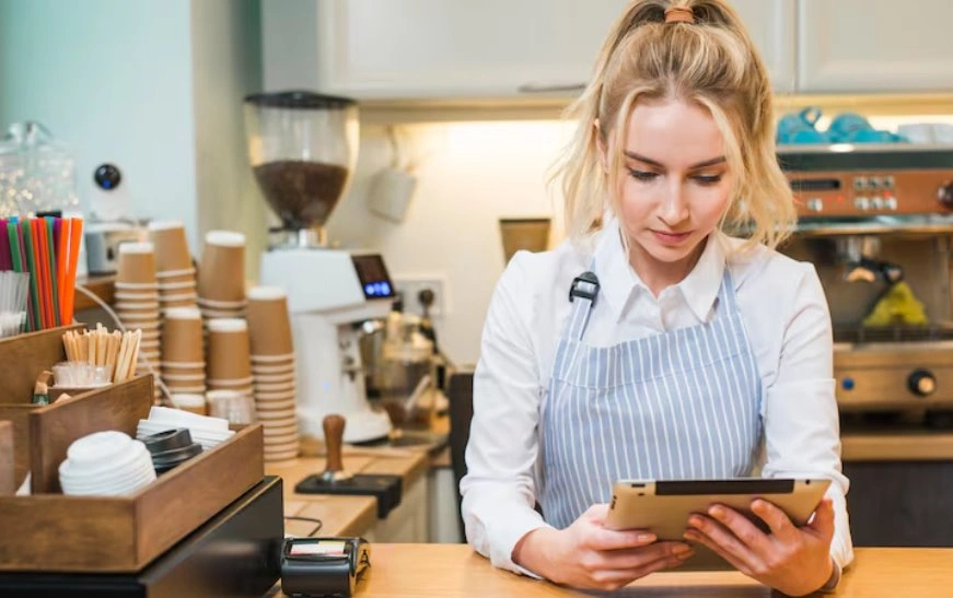 Cafe employee managing sales with POS software